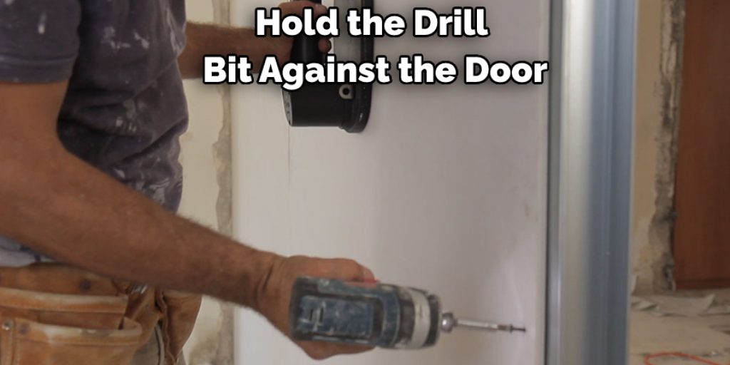 Hold the Drill Bit Against the Door