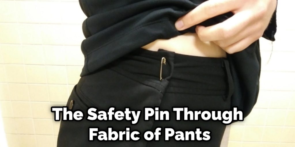 The Safety Pin Through  Fabric of Pants