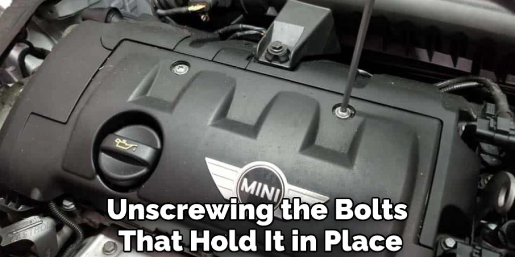 Unscrewing the Bolts That Hold It in Place