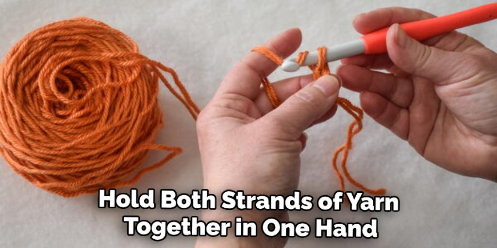 Hold Both Strands of Yarn Together in One Hand