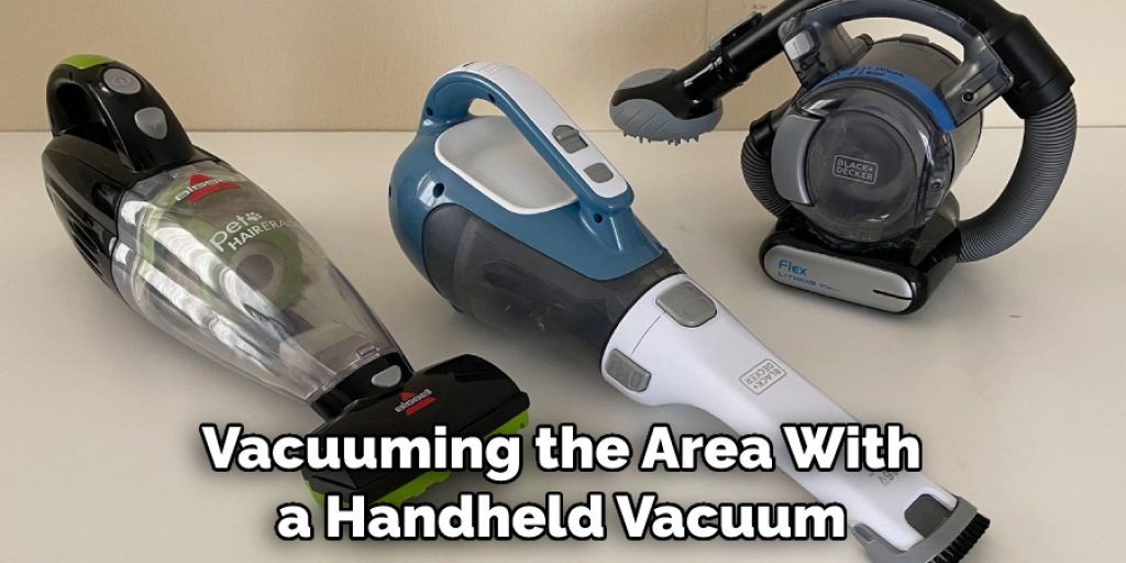 Vacuuming the Area With a Handheld Vacuum