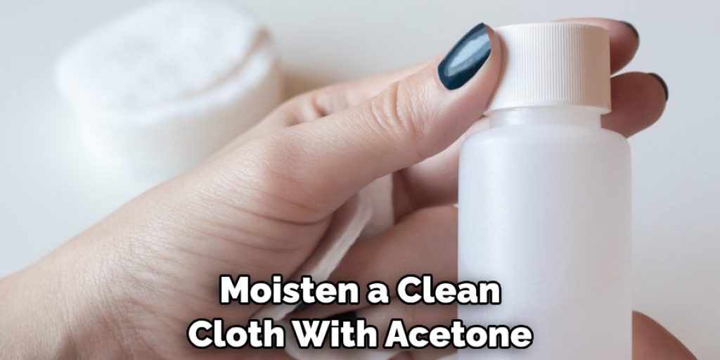 Moisten a Clean Cloth With Acetone