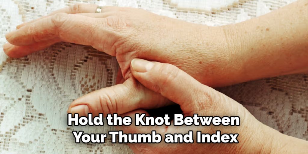 Hold the Knot Between 
Your Thumb and Index