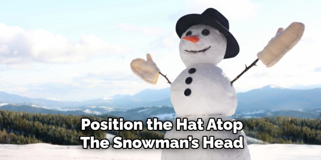 Position the Hat Atop
The Snowman’s Head