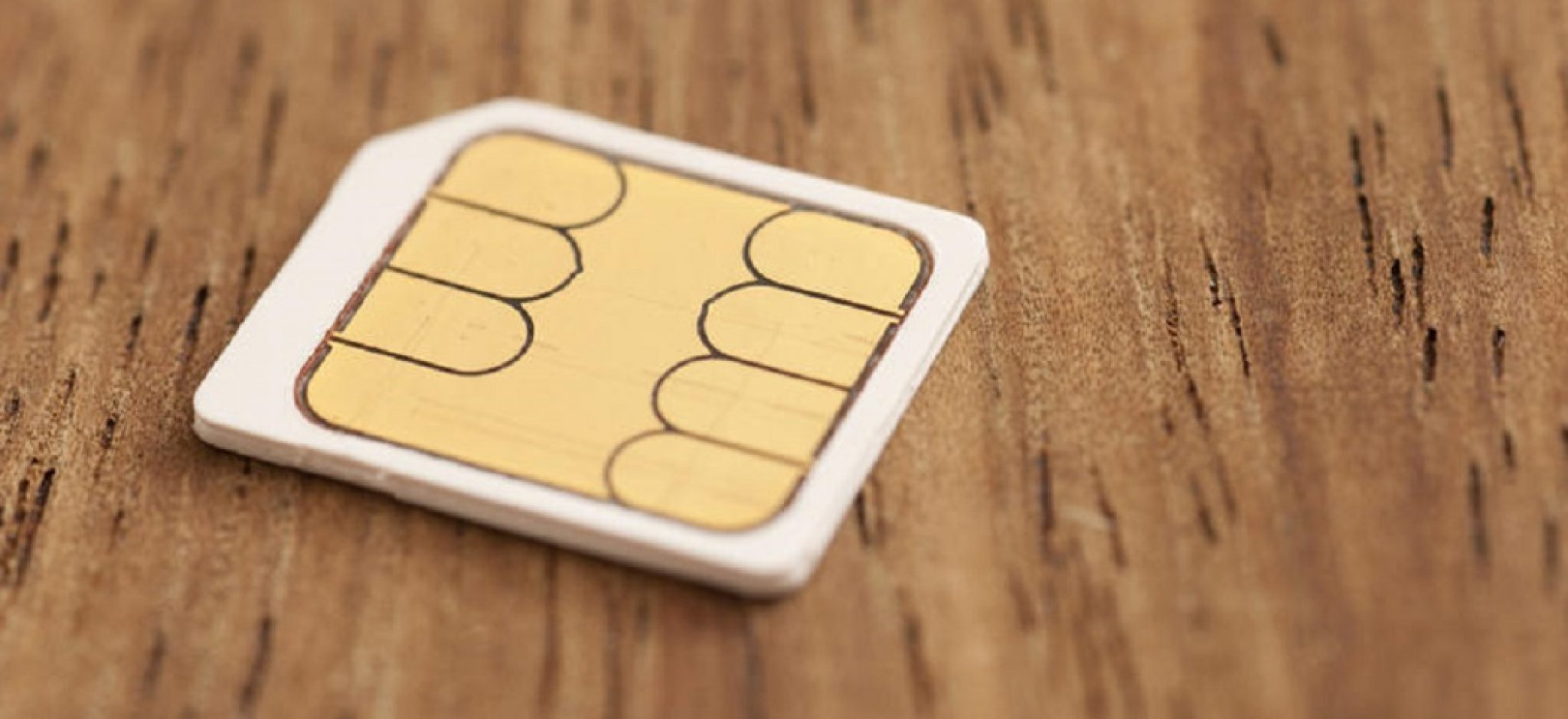  A close-up image of a damaged SIM card with a wooden background.