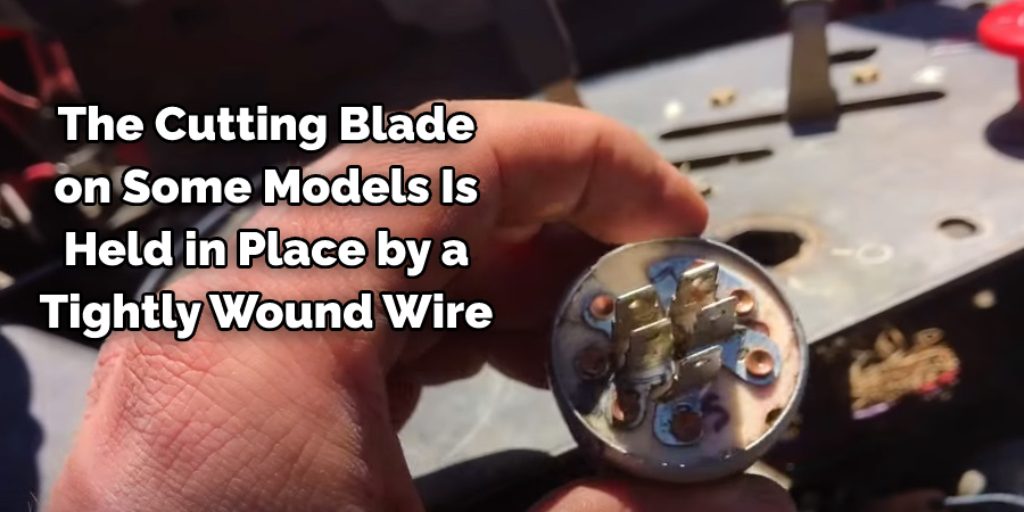 The cutting blade on some models is held in place by a tightly wound wire