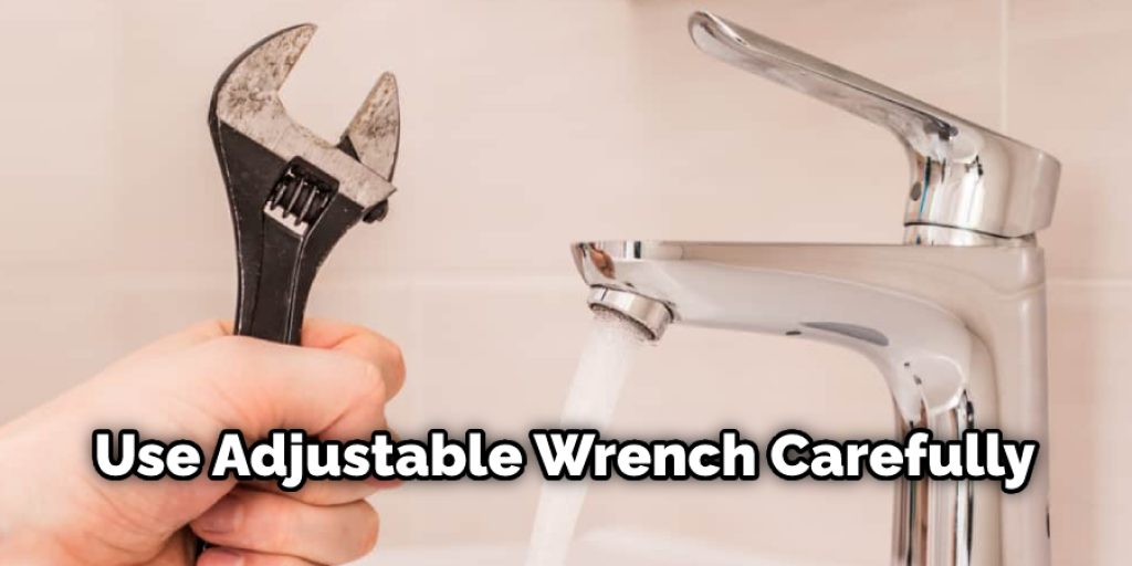 Place the adjustable wrench on the stem running to the wall, turn counter-clockwise to loosen the handle's base.