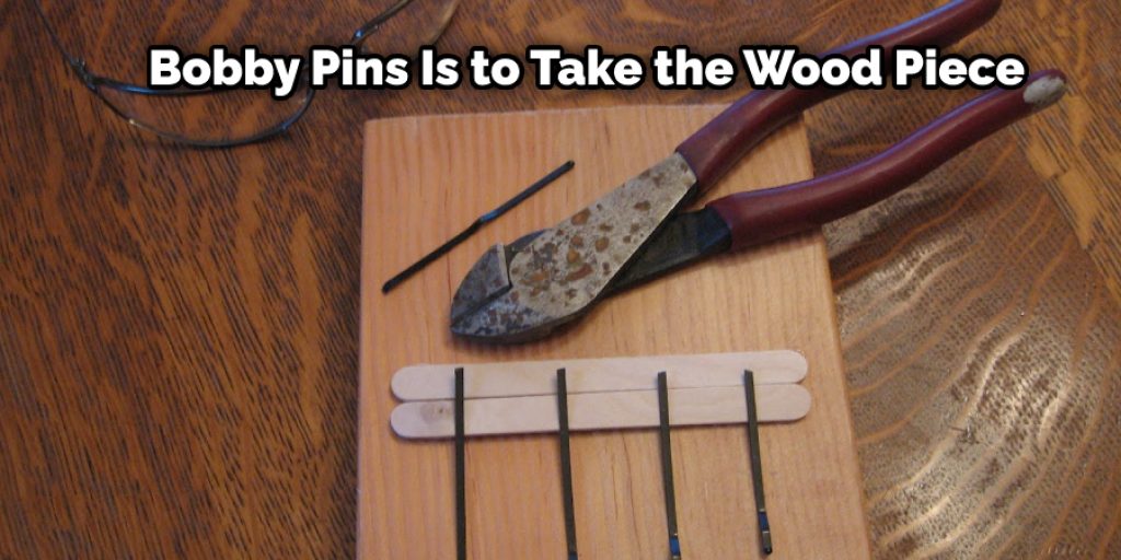 The first step of how to make a thumb piano with bobby pins is to take the wood piece.