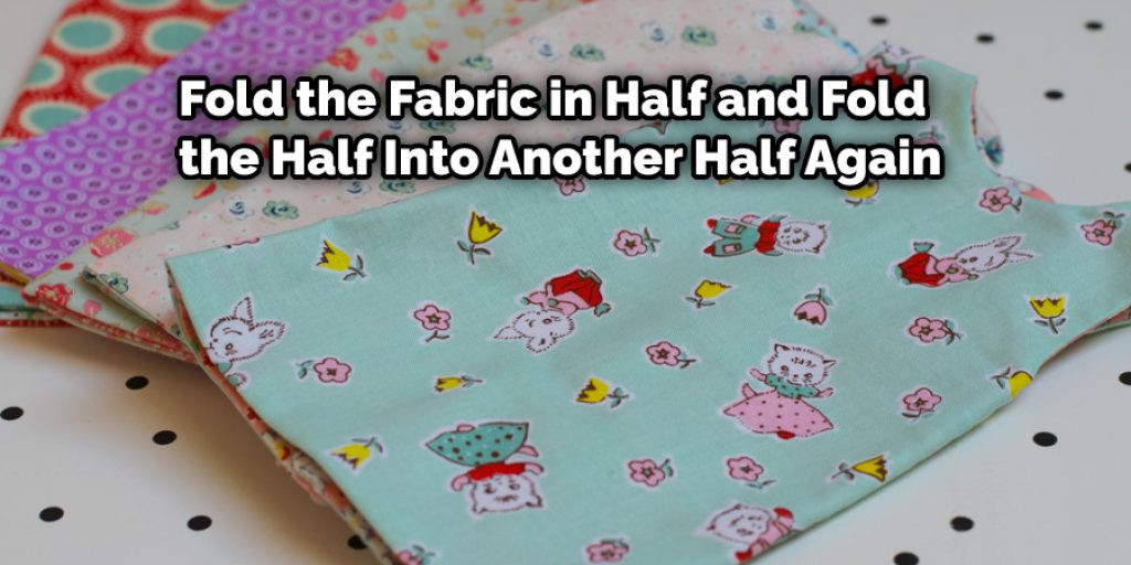 Fold the fabric in half and fold the half into another half again. 