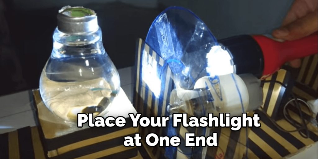 Place your flashlight at one end