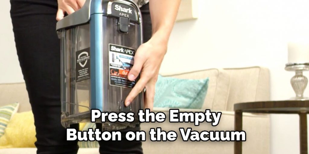 Press the Empty Button on the Vacuum