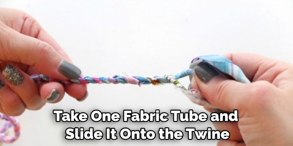 Take one fabric tube and slide it onto the twine