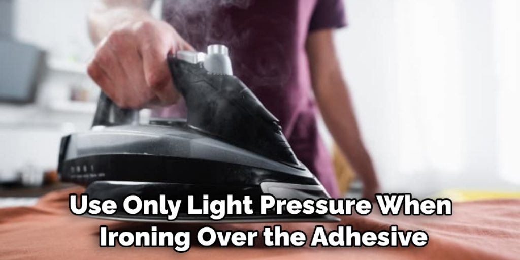 Use Only Light Pressure When Ironing Over the Adhesive